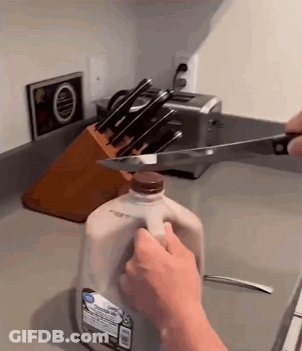 Person Cutting Into Gallon Of Milk GIF