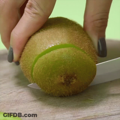 Person Cutting Kiwi In Half With Knife GIF