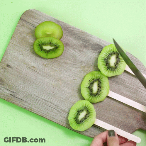 Person Cutting Kiwi Slices GIF