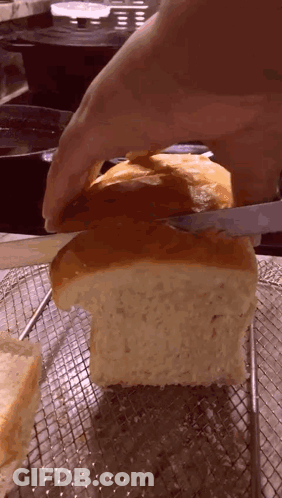 Person Cutting Loaf Of Bread On Wire Rack GIF