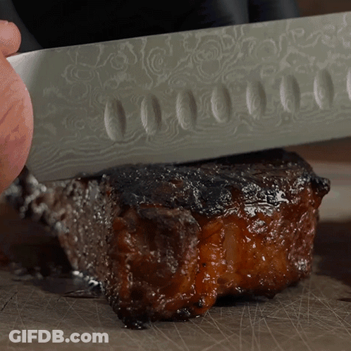 Person Cutting Meat With Patterned Knife GIF