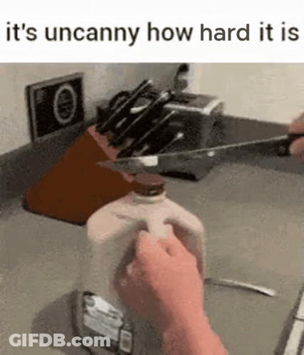 Person Cutting Milk Bottle With Knife In Kitchen GIF