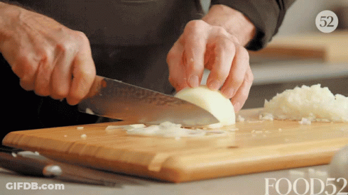 Person Cutting Onion On Food52 Cutting Board GIF