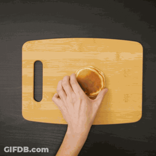 Person Cutting Pancake On Wooden Board GIF