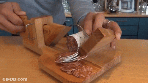 Person Cutting Sausage On Wooden Board GIF