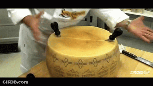 Person Cutting Trentino Cheese On Cutting Board GIF