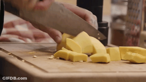 Person Cutting Yellow Cheese On Cutting Board GIF