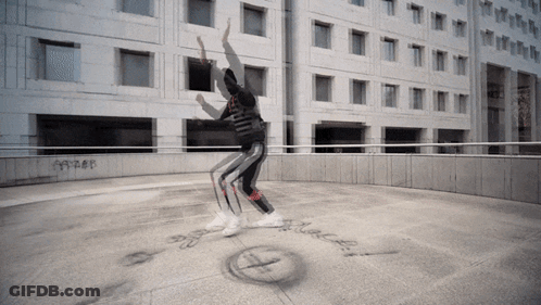 Person Dancing In Front Of Building With Black Text GIF