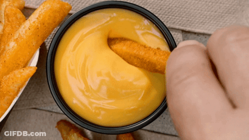 Person Dipping Chicken Nugget In Bowl Of Cheese Sauce GIF