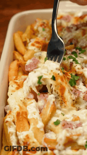 Person Dipping Fork Into Casserole Dish With Fries And Cheese GIF