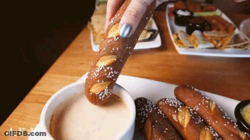 Person Dipping Pretzel In Sauce GIF