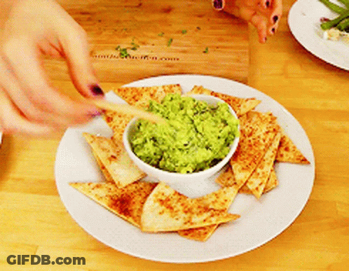 Person Dipping Tortilla Chip Into Guacamole GIF
