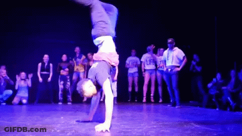Person Doing Handstand In Front Of Group Wearing Life Shirts GIF