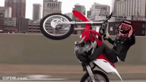 Person Doing Motorcycle Trick With Smiley Helmet GIF