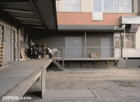 Person Doing Trick On Ramp In Warehouse GIF