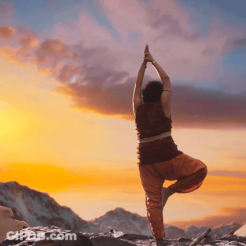 Person Doing Yoga Pose In Front Of Mountain At Sunset GIF