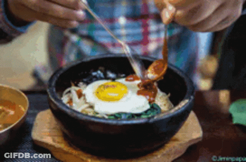 Person Eating Bowl Of Food With Spoon And Chopsticks GIF