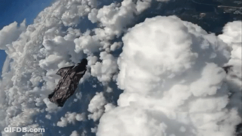 Person Flying Through Cloudy Sky With Blanket GIF