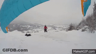Person Flying With Parachute In Snow GIF