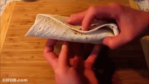 Person Folding Tortilla On Cutting Board GIF