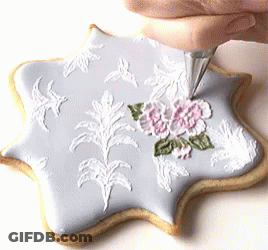 Person Frosting Cookie With White Frosting Bag GIF
