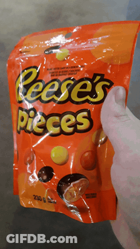 Person Holding Bag Of Reese's Pieces GIF