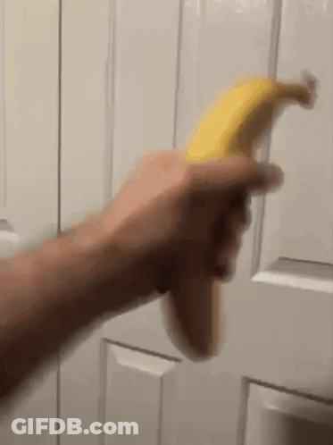 Person Holding Banana In Front Of Door GIF