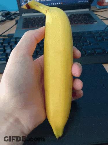 Person Holding Banana In Front Of Keyboard GIF