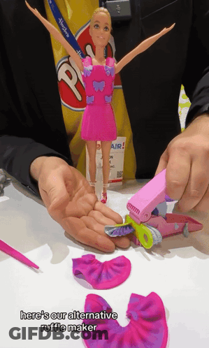Person Holding Barbie Doll And Ruffle Maker GIF