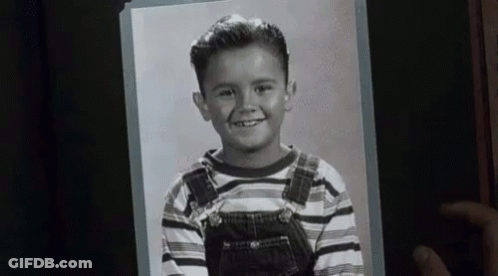 Person Holding Black And White Photo Of Boy In Overalls GIF