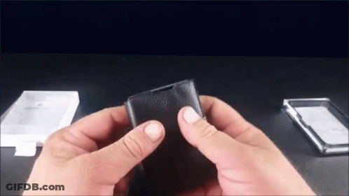 Person Holding Black Leather Wallet Next To Clear Plastic Case GIF