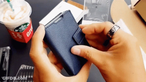 Person Holding Blue Wallet In Front Of Starbucks Cup GIF