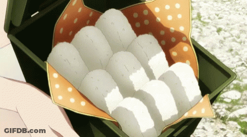 Person Holding Box Of Rice Balls On Polka Dot Cloth GIF