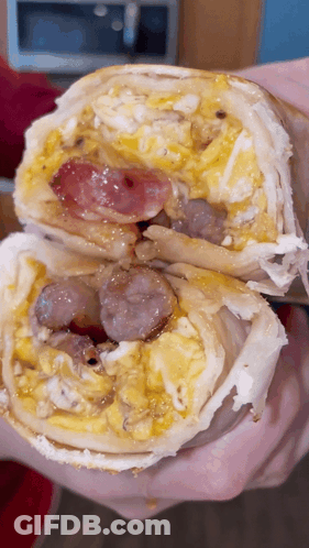 Person Holding Burrito With Eggs And Sausage GIF