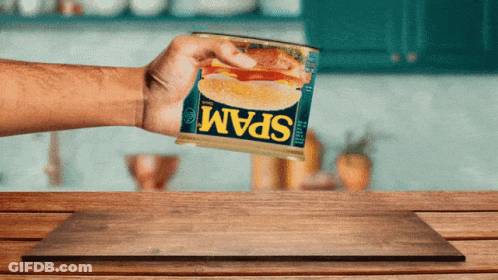 Person Holding Can Of Spam On Wooden Table GIF