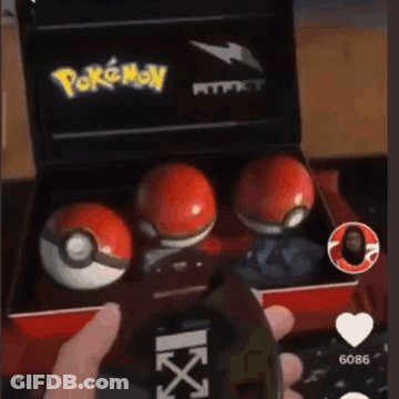 Person Holding Cell Phone And Pokemon Balls Box GIF