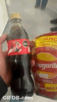 Person Holding Coca Cola Bottle Next To Bag Of Margaritas GIF