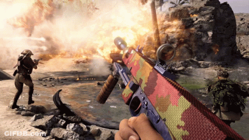 Person Holding Colorful Rifle In Front Of Fire GIF