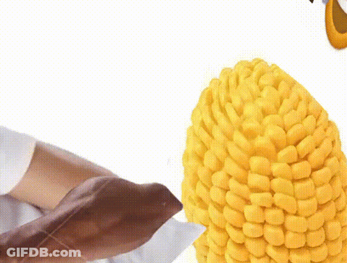 Person Holding Corn On The Cob With Knife GIF