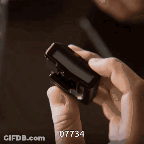 Person Holding Device With Number 07734 GIF
