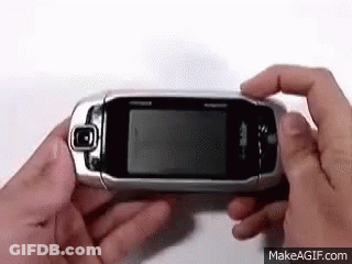 Person Holding Flip Phone Looking At It GIF