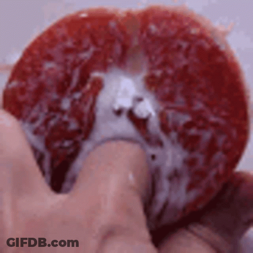 Person Holding Grapefruit Slice With Juice GIF