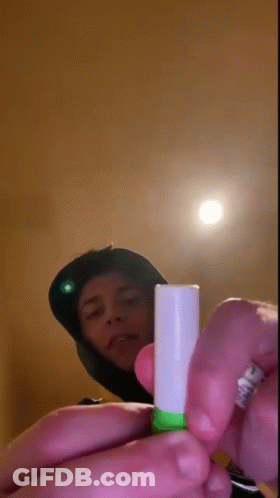 Person Holding Green And White Tube GIF