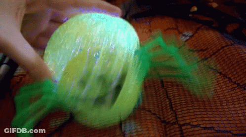 Person Holding Green Ball With Spider Web GIF