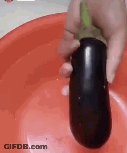 Person Holding Large Eggplant Over Red Bowl GIF
