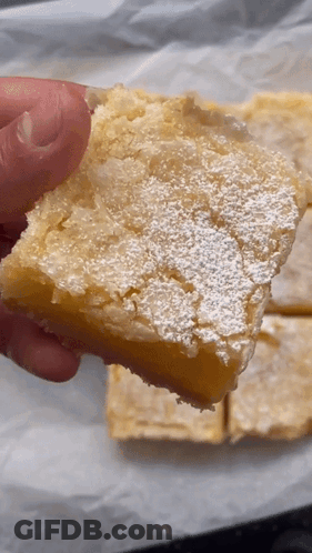 Person Holding Lemon Bar With Powdered Sugar GIF