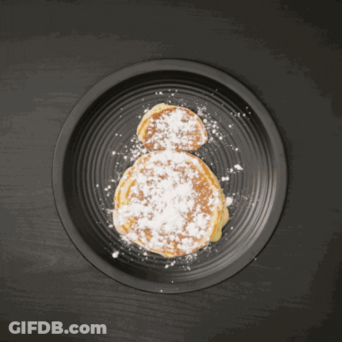 Person Holding Orange Slice Over Pancake GIF