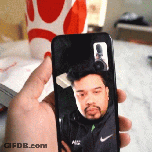 Person Holding Phone With Man On Screen GIF