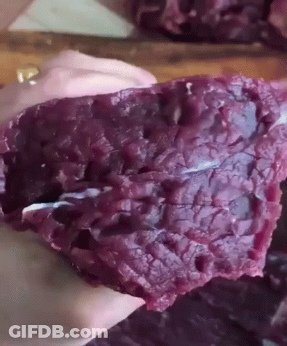 Person Holding Piece Of Purple Meat GIF