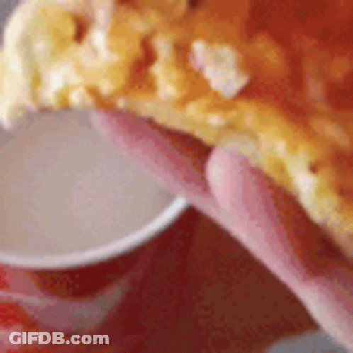 Person Holding Pizza Slice Next To Sauce Cup GIF